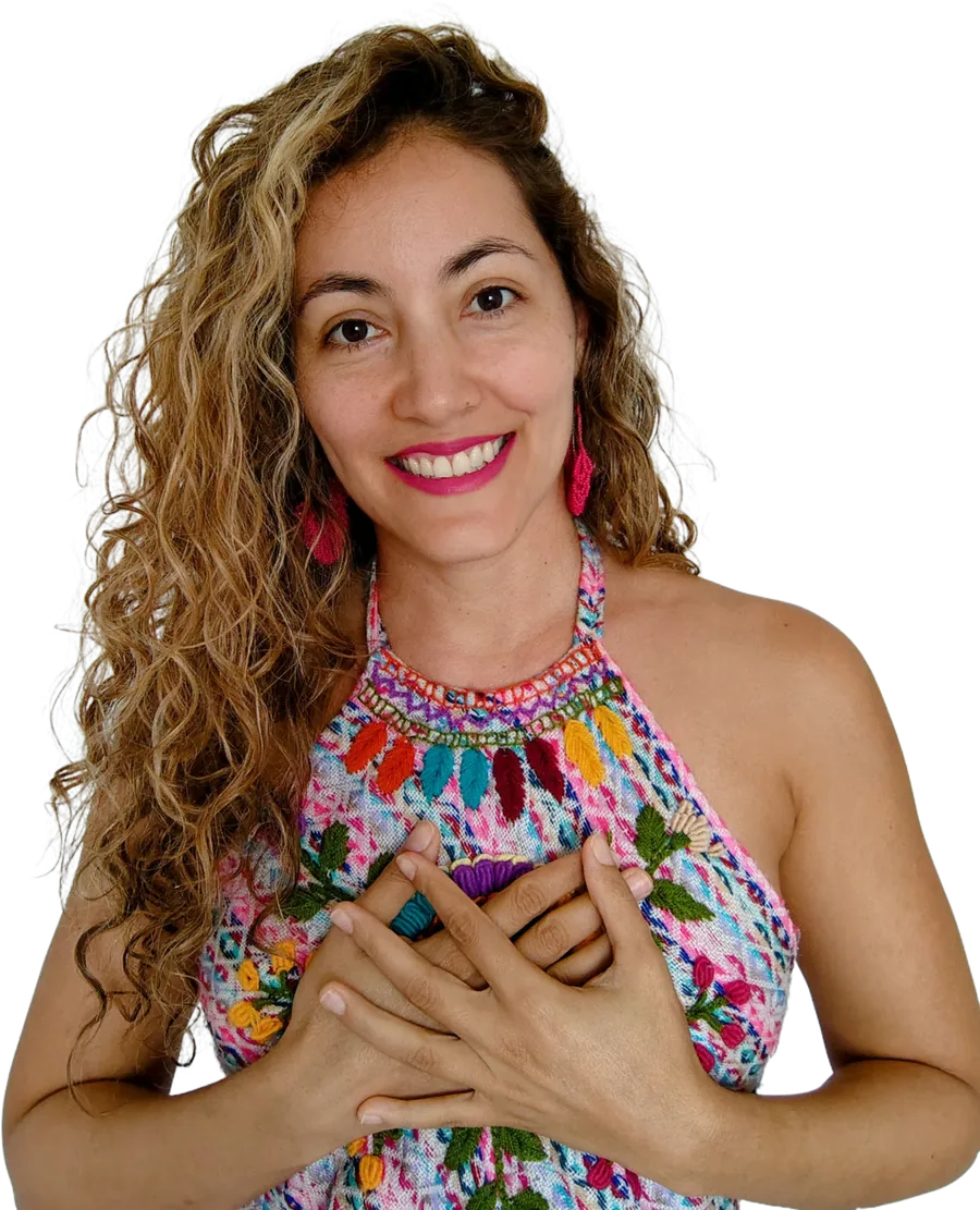 Luz sonriendo, con las manos en el corazón y una blusa bordada de colores